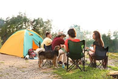 Photo of People having lunch near camping tent outdoors