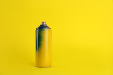 Photo of Used can of spray paint on yellow background. Space for text