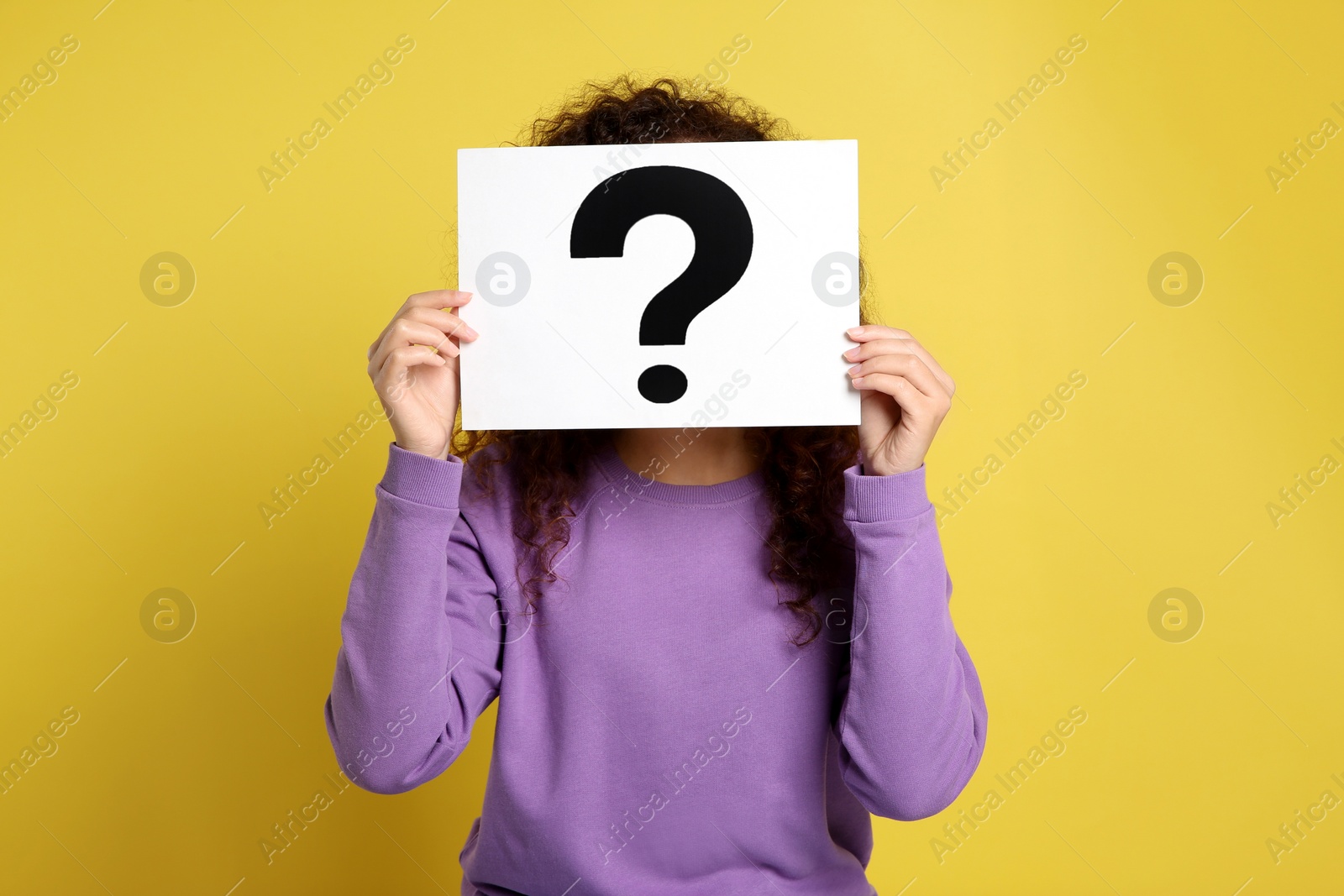 Photo of Woman with question mark sign on yellow background