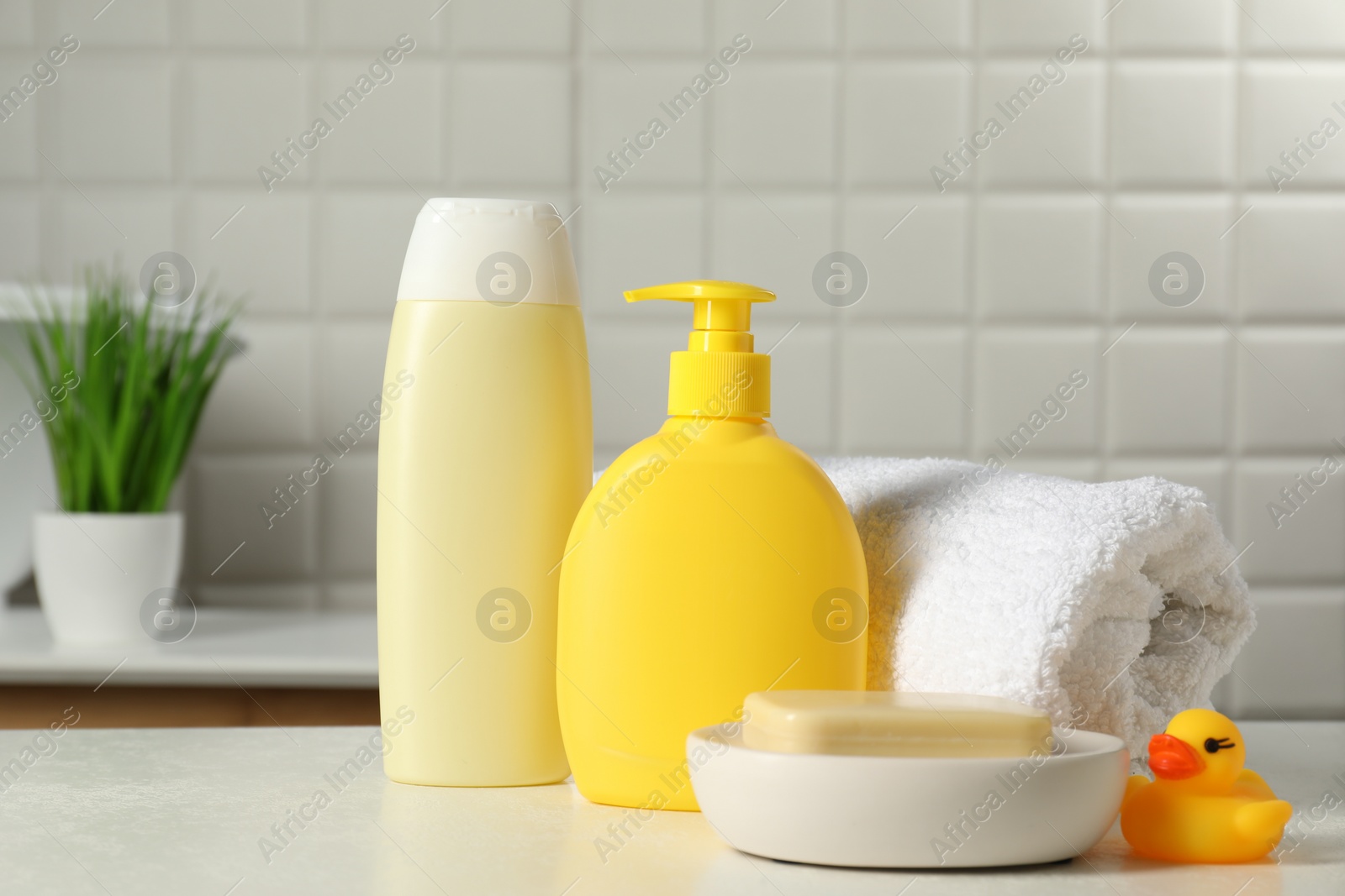 Photo of Baby cosmetic products, bath duck and towel on white table