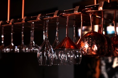 Photo of Different glassware hanging on bar counter, closeup