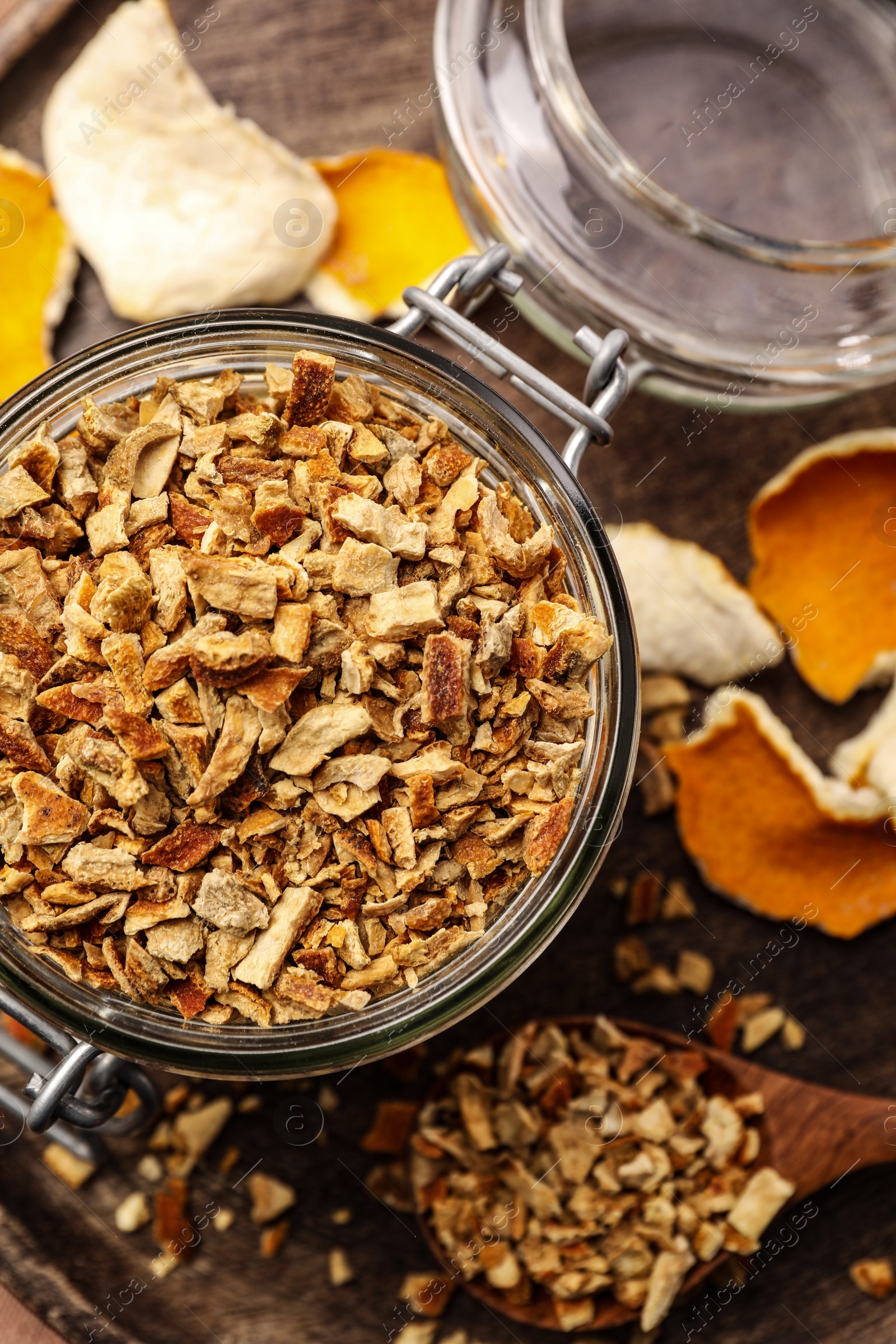 Photo of Tray with jar of dried orange zest seasoning on wooden table, flat lay