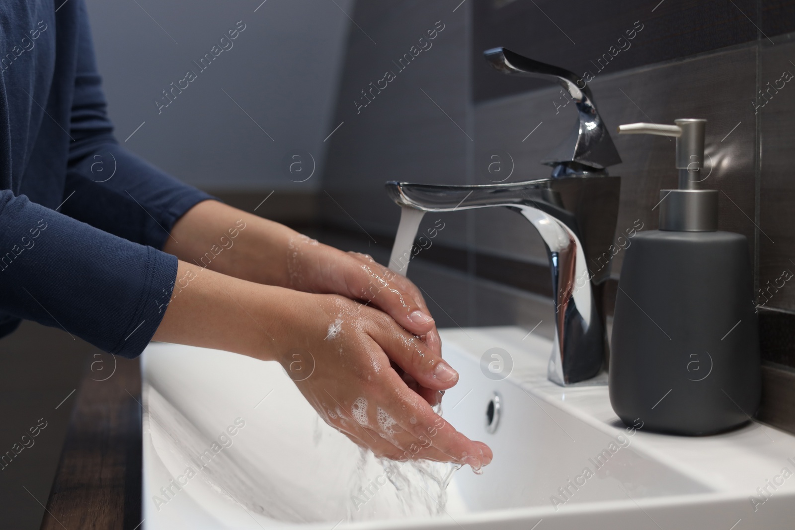 Photo of Woman washing hands in bathroom, closeup view