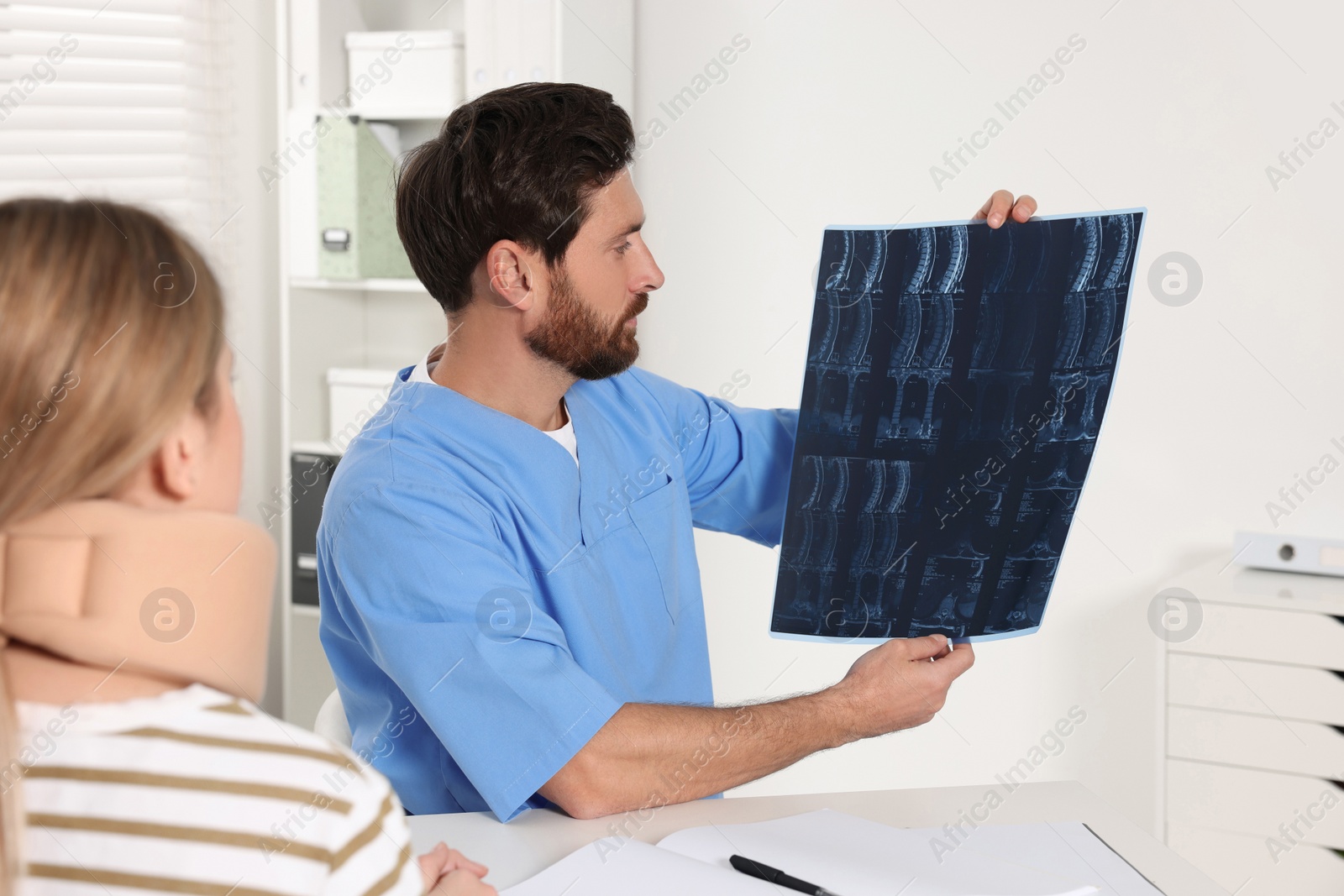Photo of Doctor with neck MRI scan consulting patient in hospital