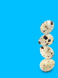 Image of Stacked speckled quail eggs on light blue background. Space for text