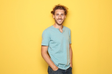 Photo of Young man in casual clothes posing on color background