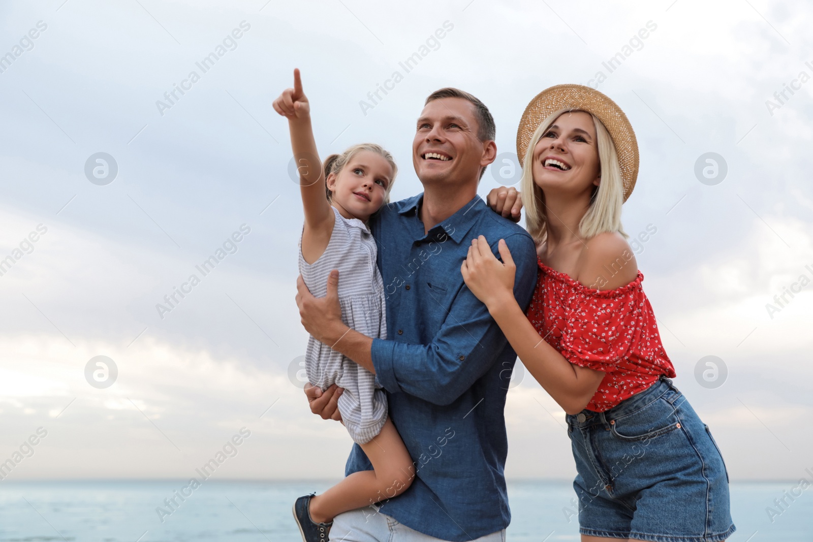 Photo of Happy family spending time together near sea on sunny summer day