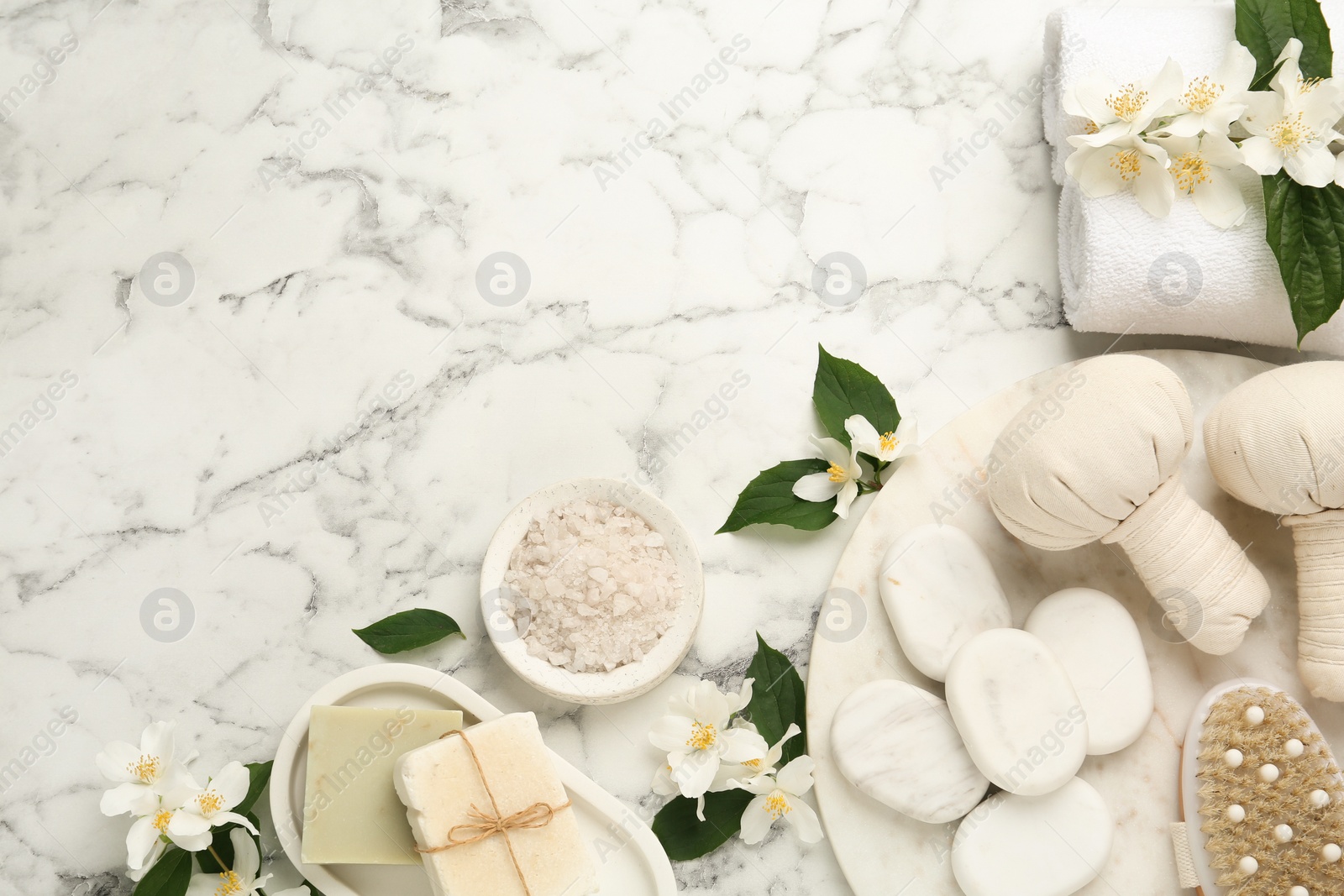 Photo of Flat lay composition with beautiful jasmine flowers and spa stones on white marble table, space for text