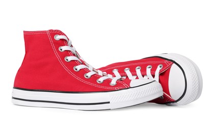 Photo of Pair of new red stylish high top plimsolls on white background