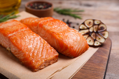 Photo of Delicious roasted fish on wooden board, closeup