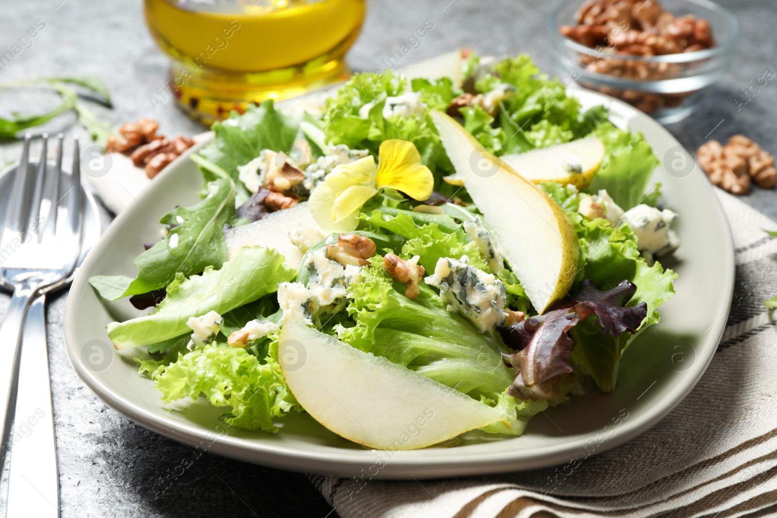 Photo of Fresh salad with pear served on grey table