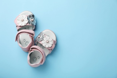 Photo of Pair of cute baby sandals on color background, top view