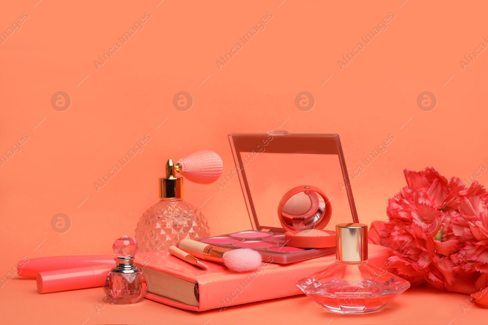 Photo of Beautiful composition with coral beauty accessories, notebook and flowers on color background