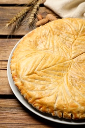 Photo of Traditional galette des rois on wooden table, closeup