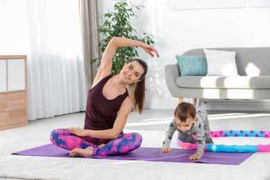 Woman doing fitness exercises together with son at home