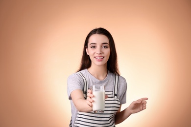 Photo of Beautiful young woman drinking milk on color background