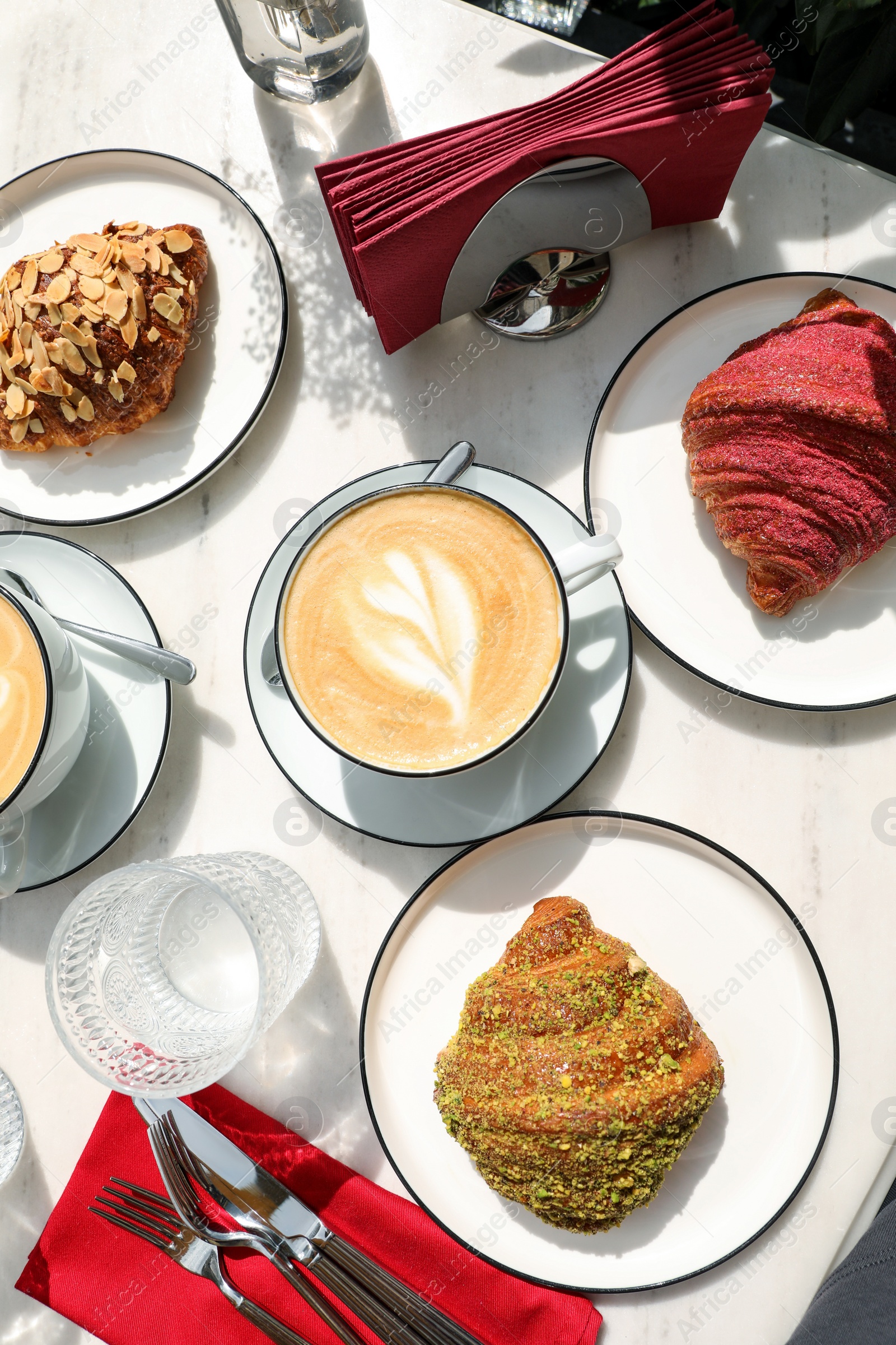 Photo of Delicious croissants served on white marble table, flat lay