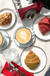 Delicious croissants served on white marble table, flat lay