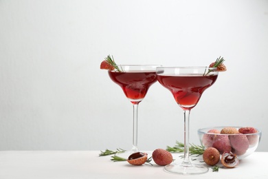 Photo of Lychee cocktail with rosemary on white table