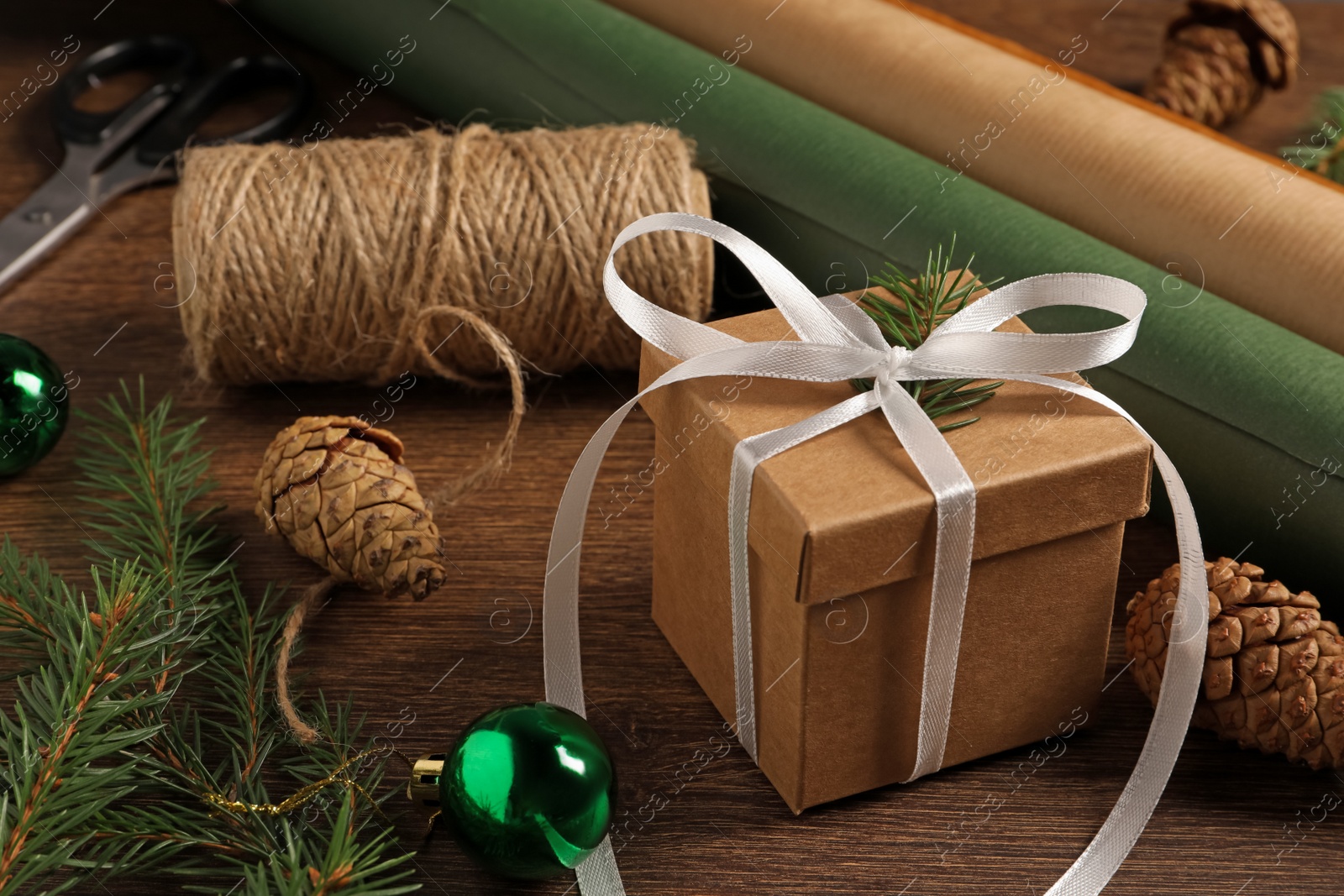Photo of Beautiful gift box and Christmas decorations on wooden table