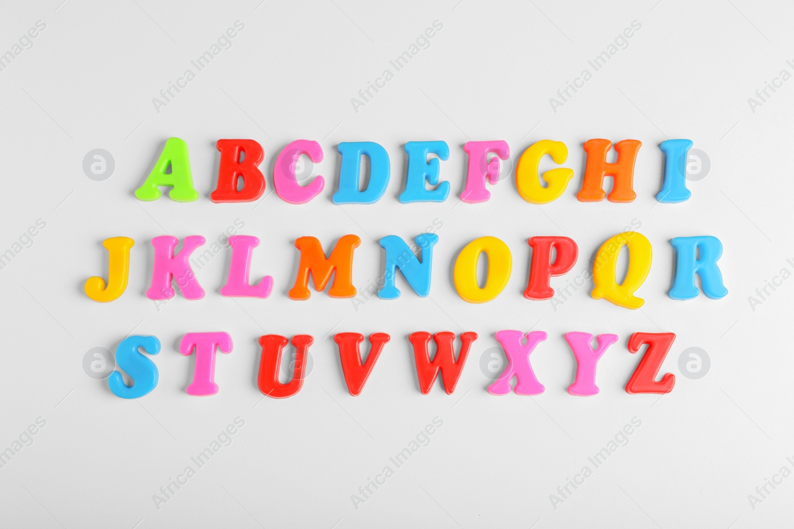 Photo of Colorful magnetic letters on white background, flat lay. Alphabetical order