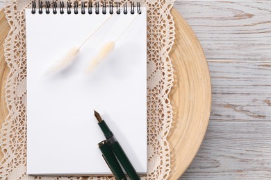 Photo of Guest list. Notebook, pen, spikelets and lace ribbon on wooden background, flat lay. Space for text