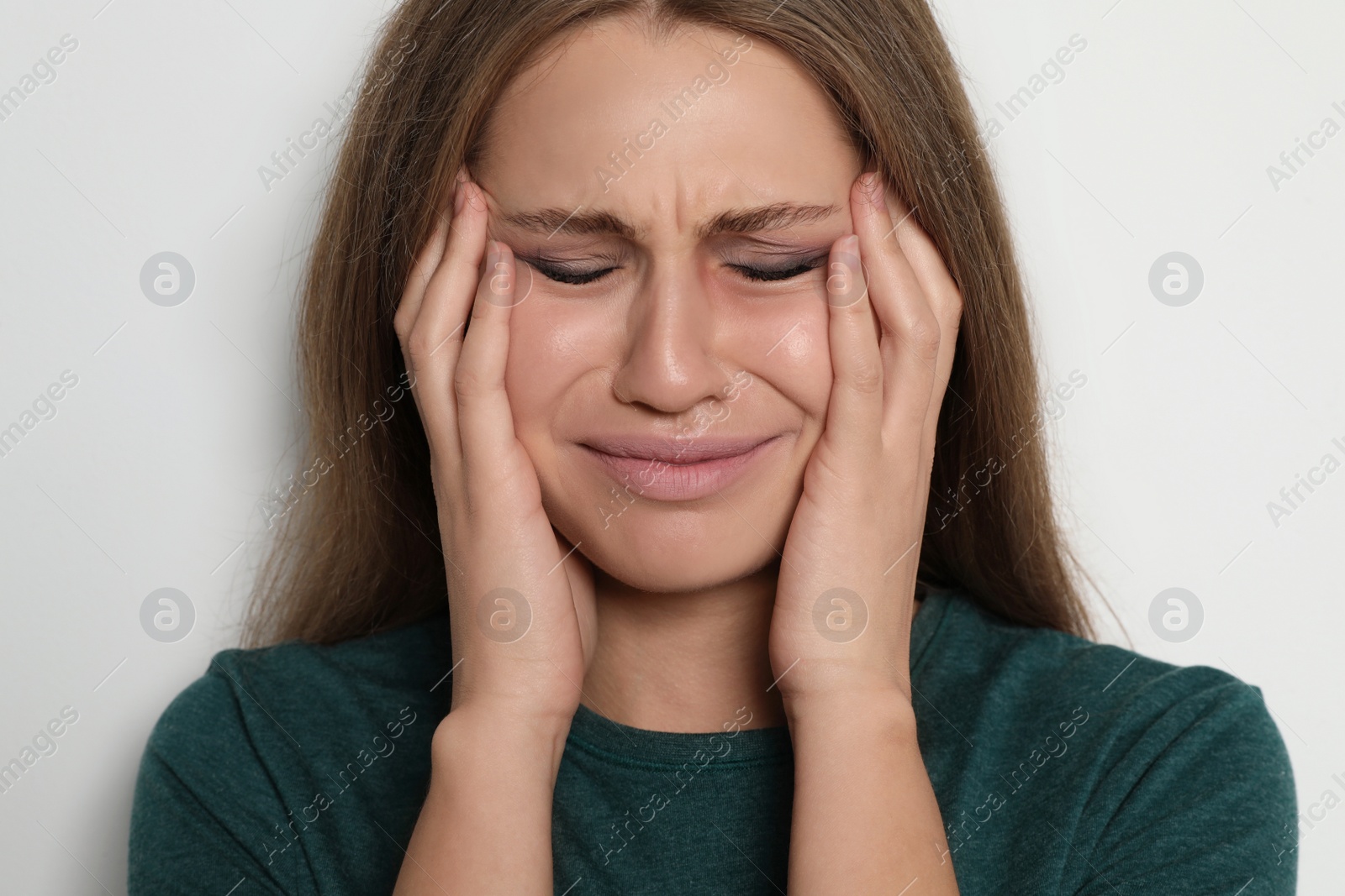 Photo of Crying young woman on light background. Stop violence