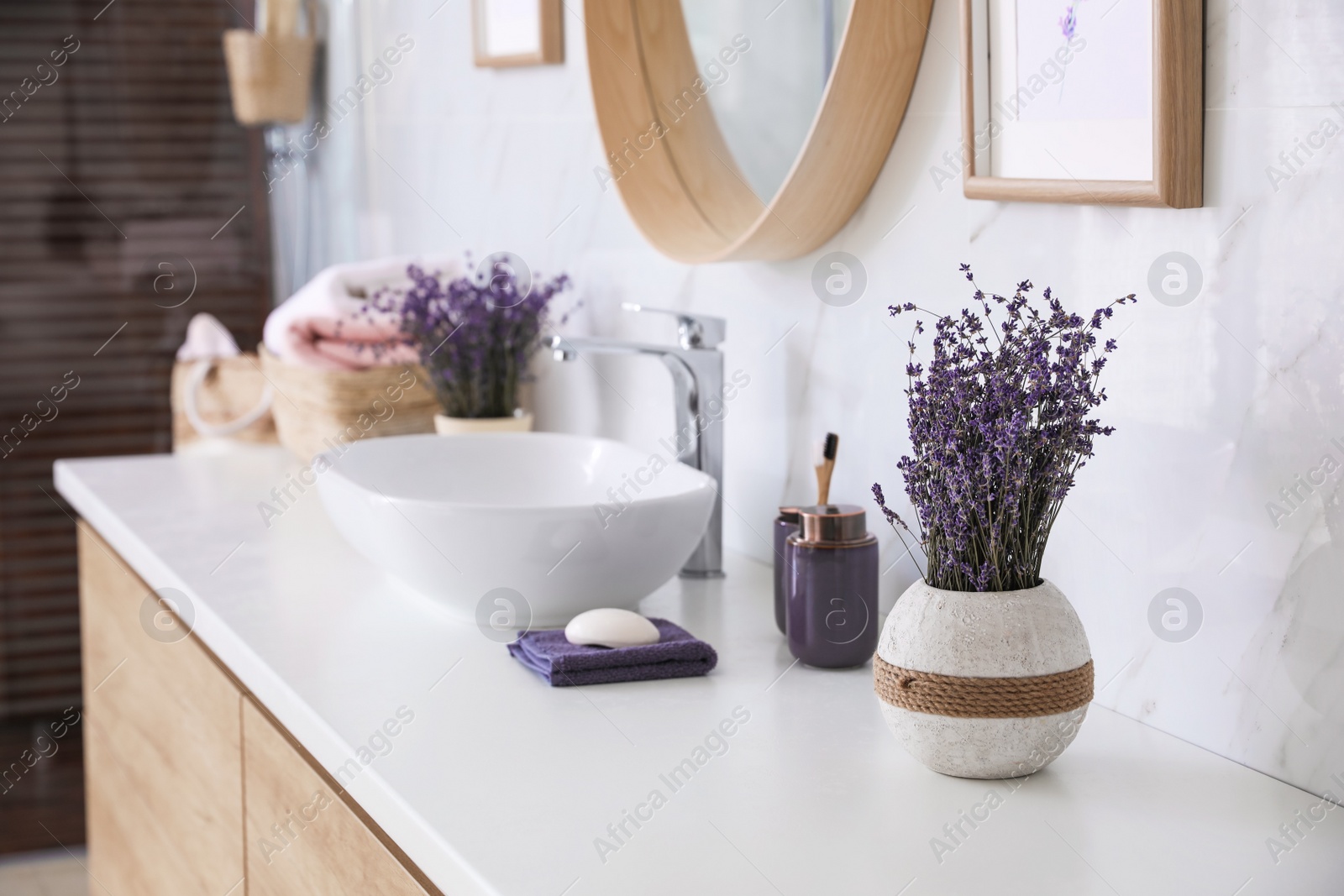 Photo of Vase with dried lavender flowers on bathroom counter. Interior design