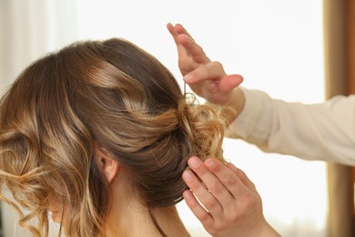 Stylist working with client in salon, making hairstyle