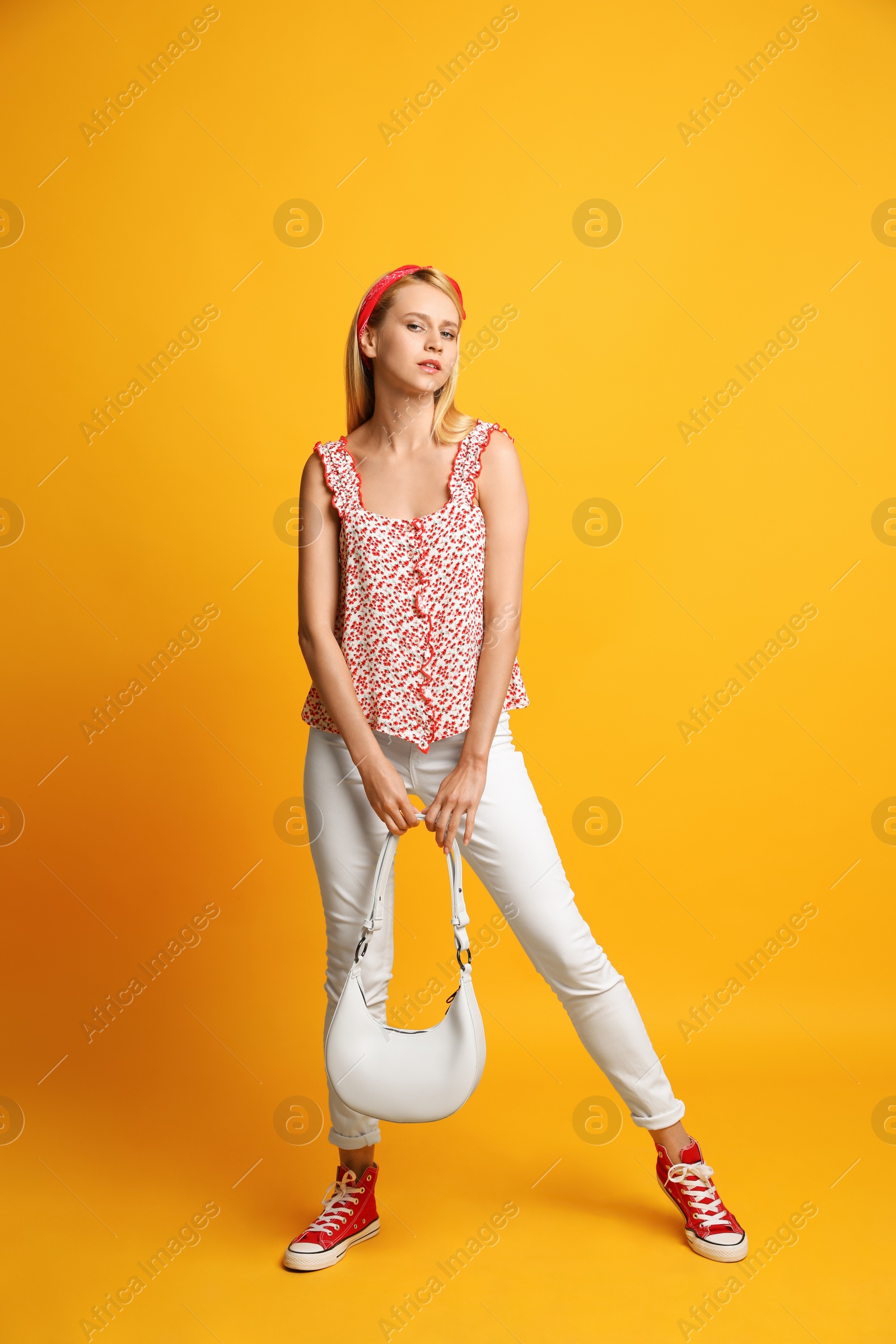 Photo of Beautiful stylish woman with trendy baguette bag on yellow background