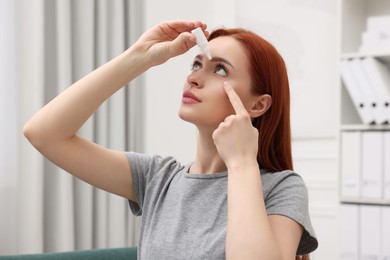 Woman applying medical eye drops at home