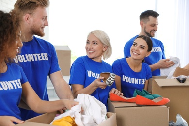 Team of volunteers collecting donations in boxes indoors