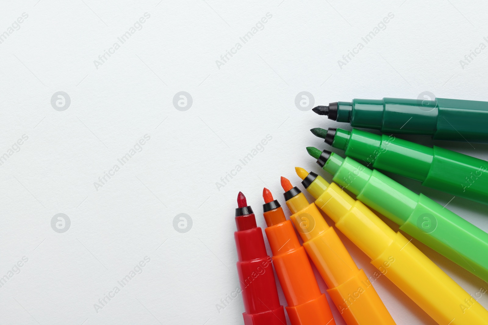 Photo of Flat lay composition with colorful markers on white background. Energy efficiency concept