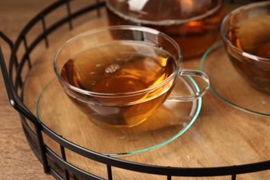 Photo of Aromatic tea in glass cups on wooden table, closeup