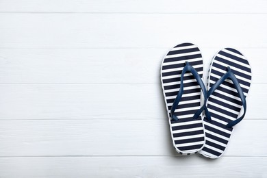 Stylish flip flops on white wooden background, flat lay. Space for text