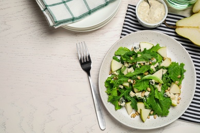 Photo of Tasty salad with pear slices served on white wooden table, flat lay. Space for text