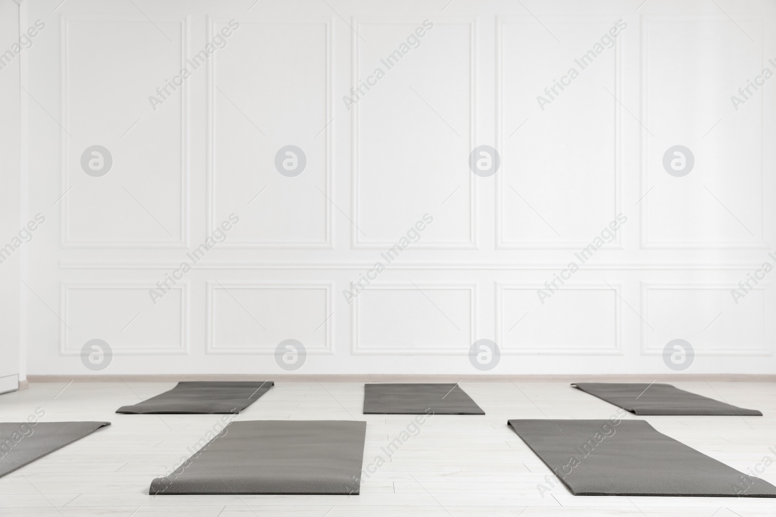 Photo of Spacious yoga studio with exercise mats. Space for text