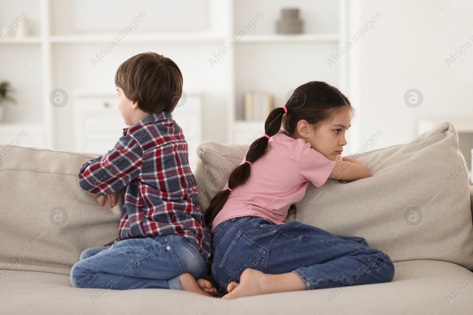 Photo of Upset brother and sister on sofa at home