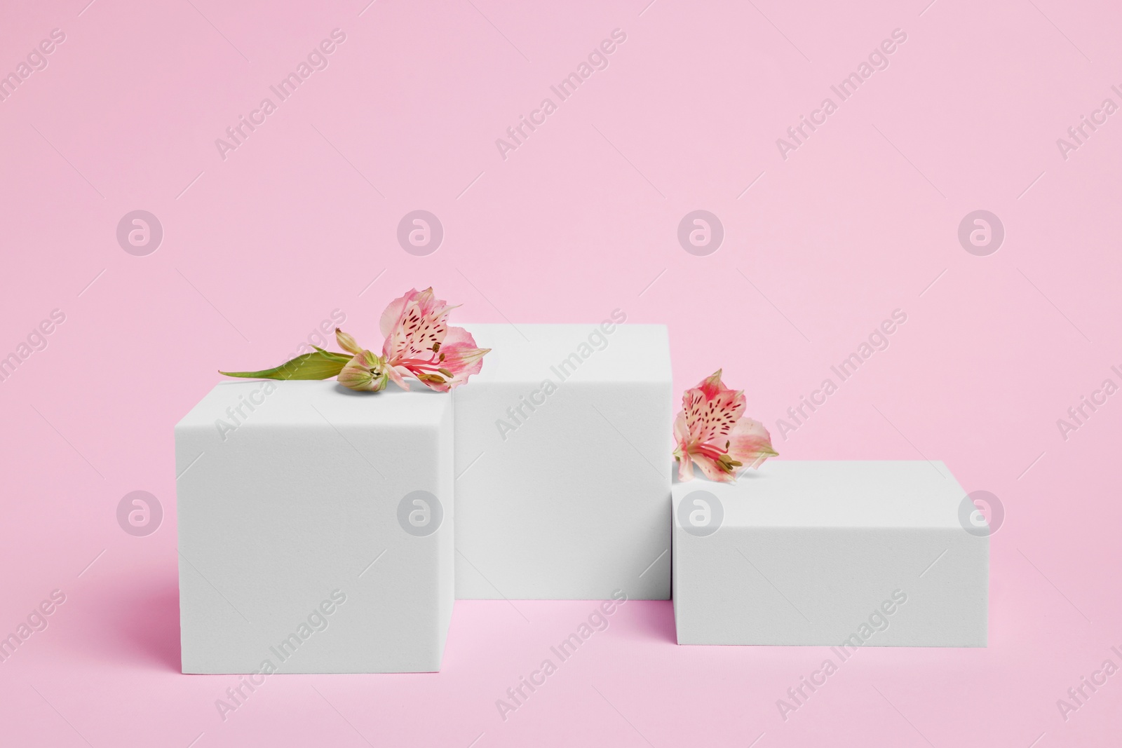 Photo of Scene for product presentation. Podiums of different geometric shapes and flowers on pink background