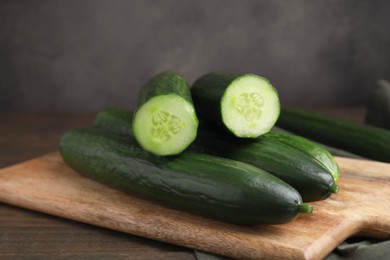 Many fresh cucumbers on wooden table, closeup