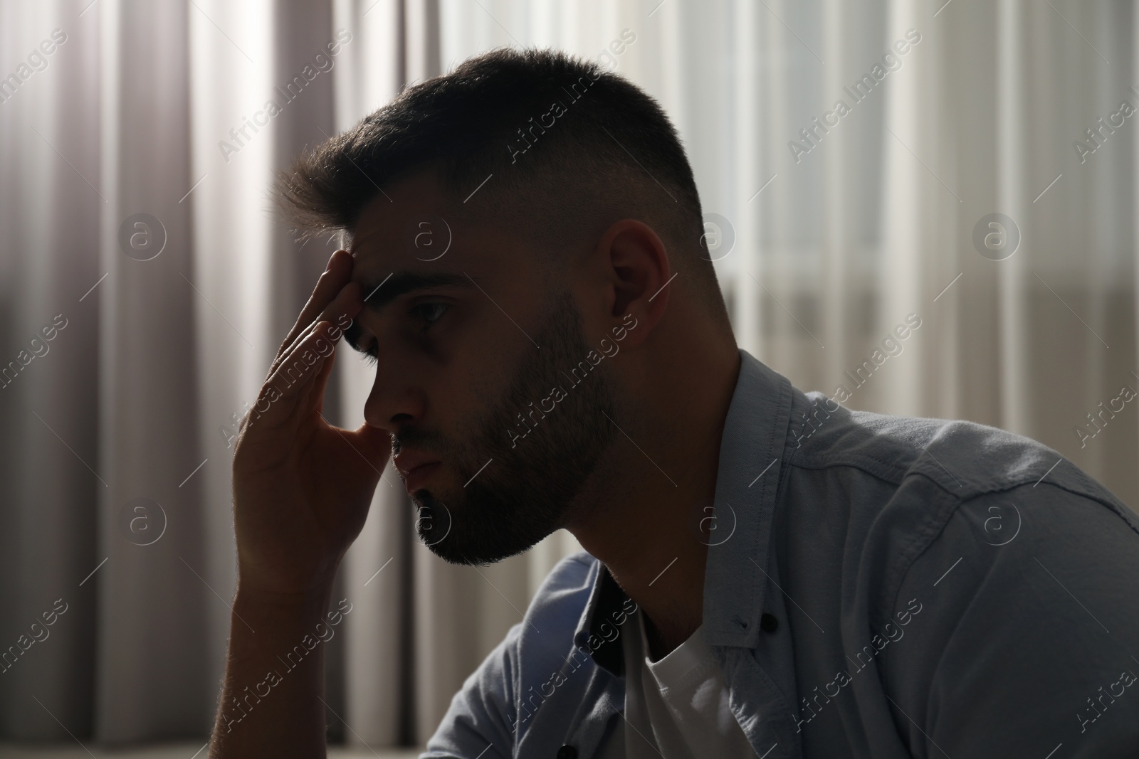 Photo of Sad young man near on blurred background