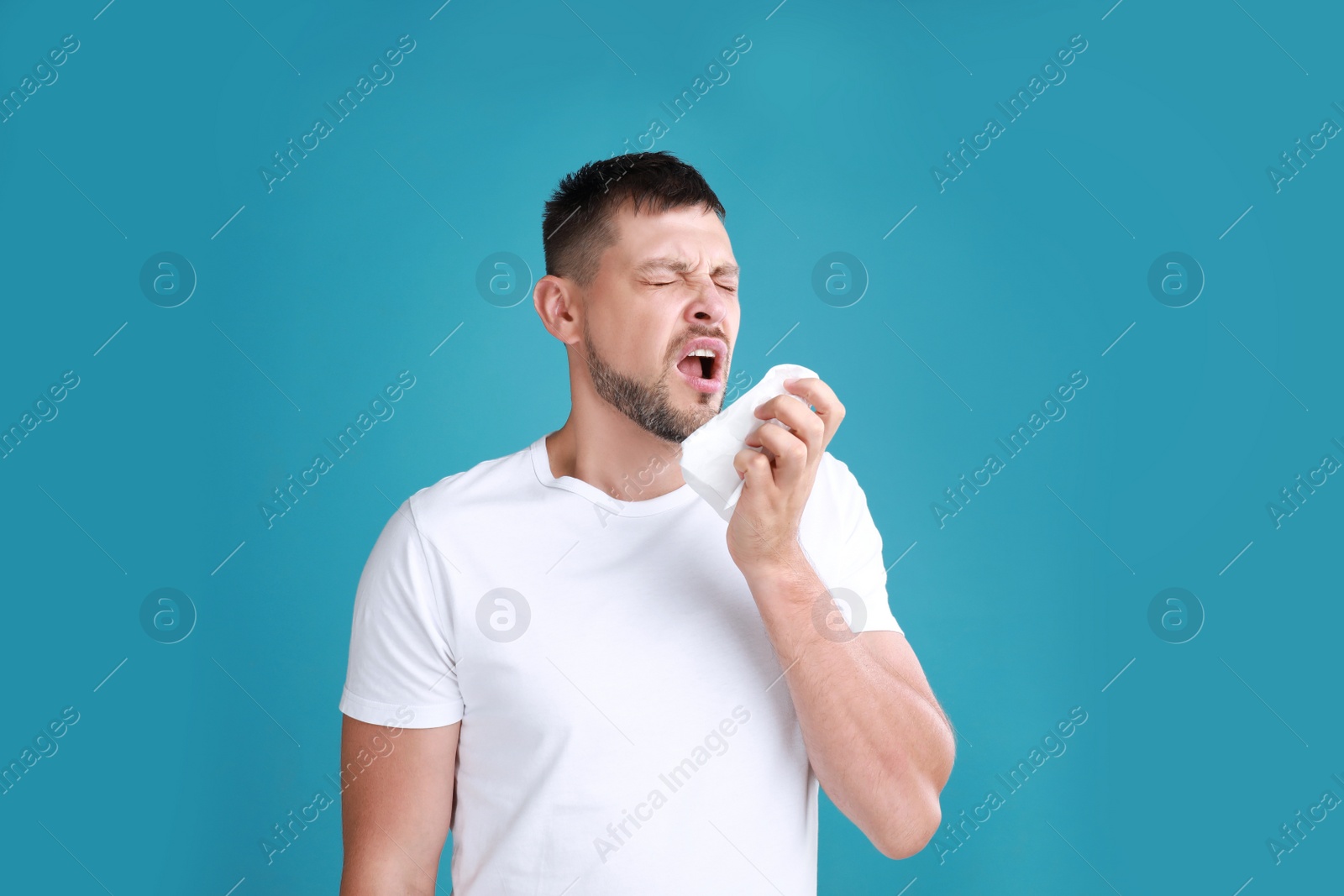 Photo of Man suffering from allergy on blue background