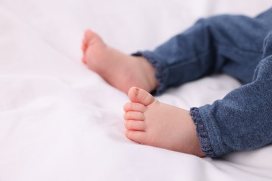 Newborn baby lying on white blanket, closeup