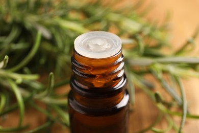 Bottle of rosemary oil on blurred background, closeup