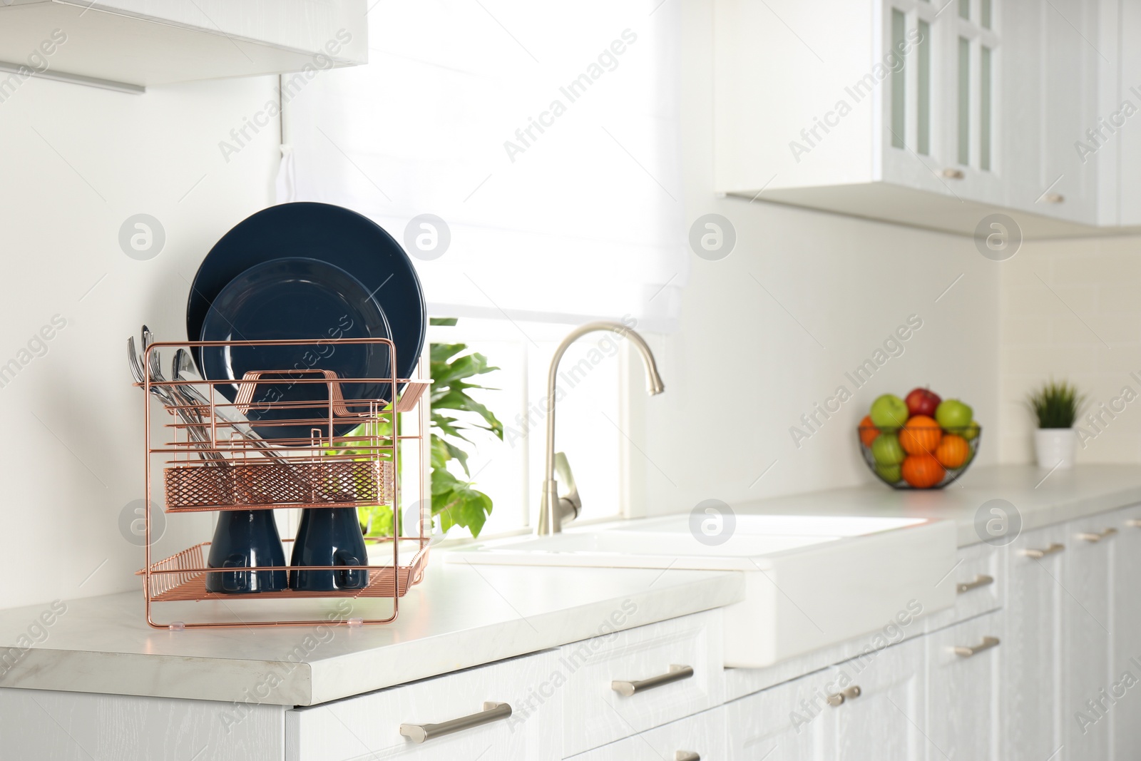 Photo of Drying rack with clean dishes on countertop in kitchen. Space for text