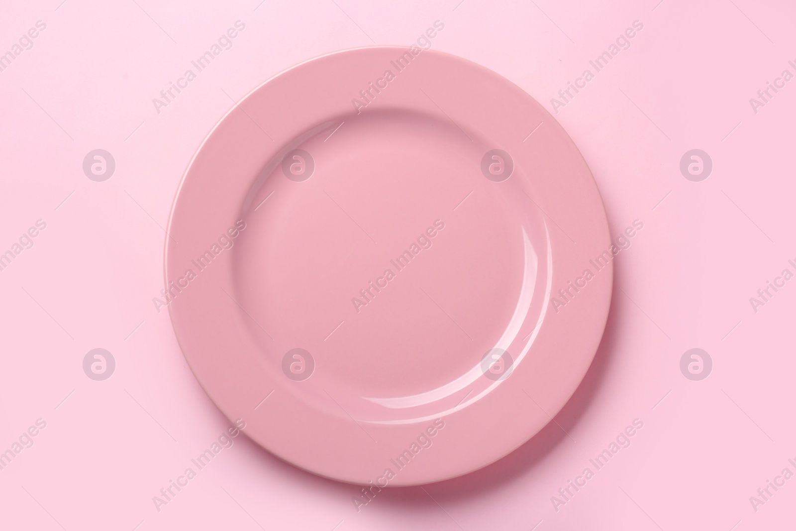 Photo of Empty ceramic plate on pink background, top view