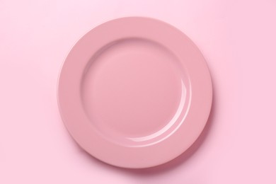 Photo of Empty ceramic plate on pink background, top view
