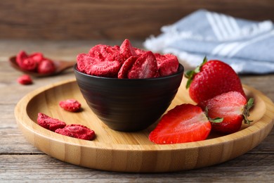 Photo of Freeze dried and fresh strawberries on wooden table, closeup