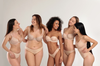 Photo of Group of women with different body types in underwear on light background