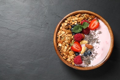 Photo of Healthy homemade granola with yogurt on dark grey table, top view. Space for text